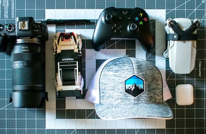 A camera, video game controller, Airpods and other hobby related objects